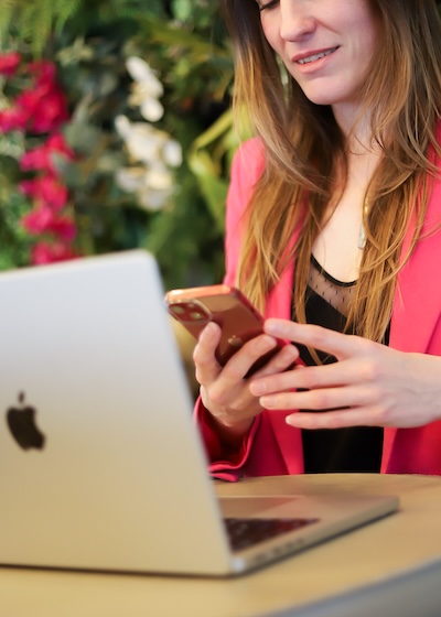 Photo de Vanessa Adis, face à un macbook, recevant un message sur son smartphone